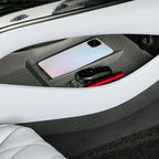 Grey textured car console organizer tray holding a smartphone, key fob, and red pen.