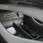 Black textured anti-slip storage tray with USB ports and 12V power outlet in car console.