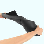 Hands demonstrating the flexibility of a durable black rubber car floor mat.