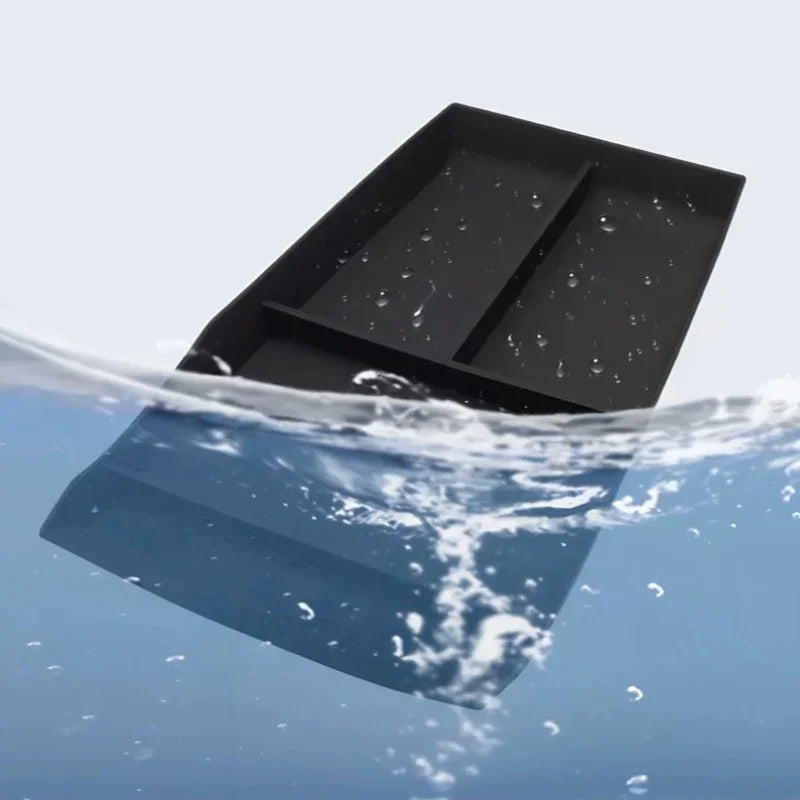 Black waterproof car cup holder tray being splashed with water.