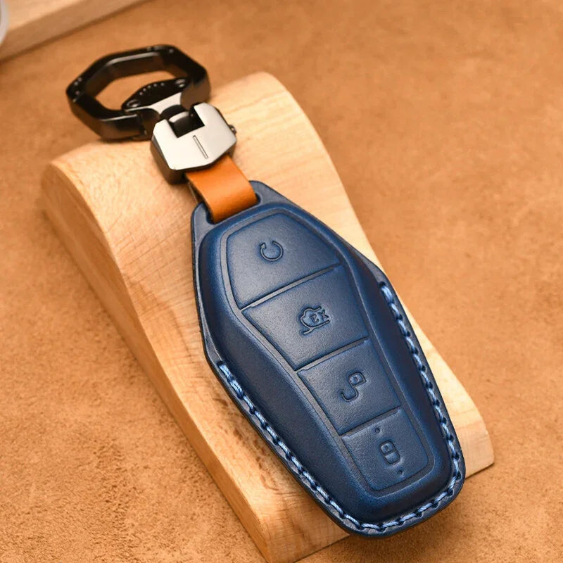 Premium navy blue leather car key fob cover with precise stitching and silver metal clip.