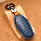 Premium navy blue leather car key fob cover with precise stitching and silver metal clip.