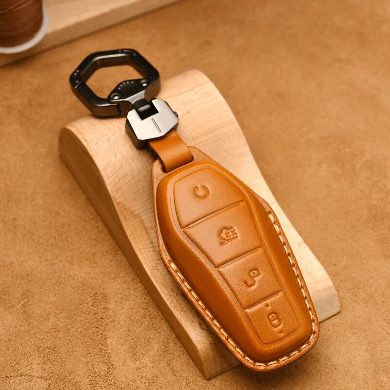 Premium tan leather car key fob cover with durable stitching and a black metal carabiner.