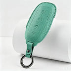 Premium teal green textured leather key fob with embossed lettering and silver metal ring.