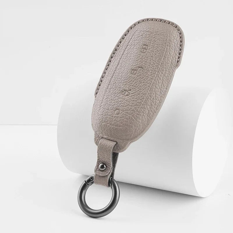 Premium beige textured leather car key fob cover with a durable metal ring.