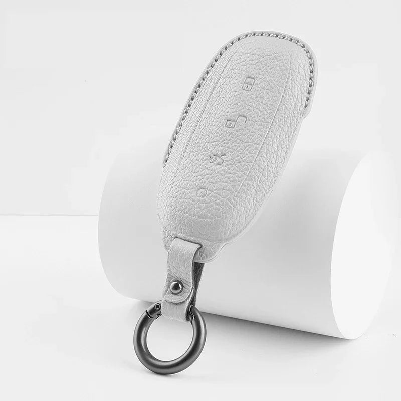 Premium white textured leather car key fob cover with a durable metal ring attachment.