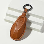 Professional brown leather car key cover with embossed logo and metal keyring.