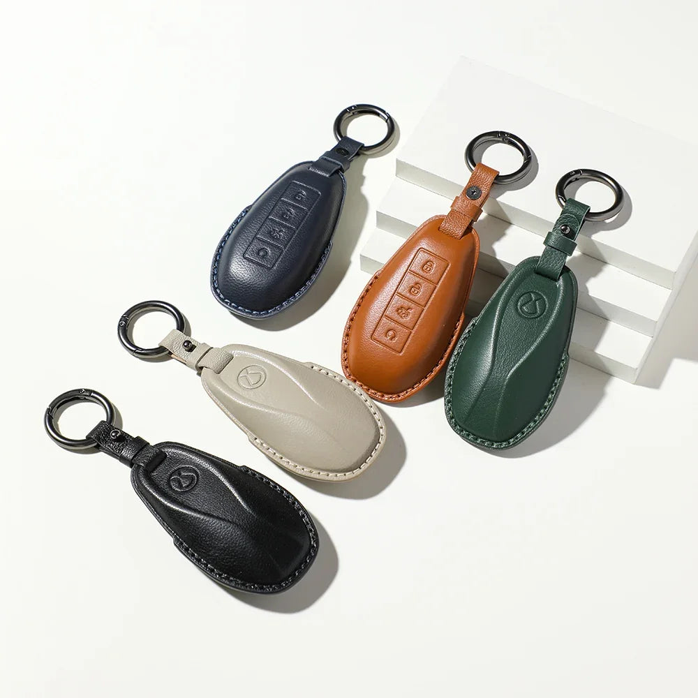 Premium leather BYD car key covers in navy, brown, green, beige, and black.