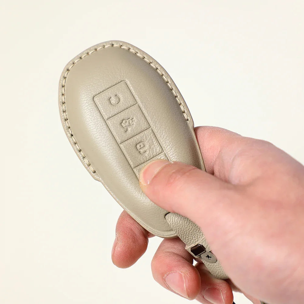 Premium beige leather car key fob cover with precise stitching for enhanced protection.