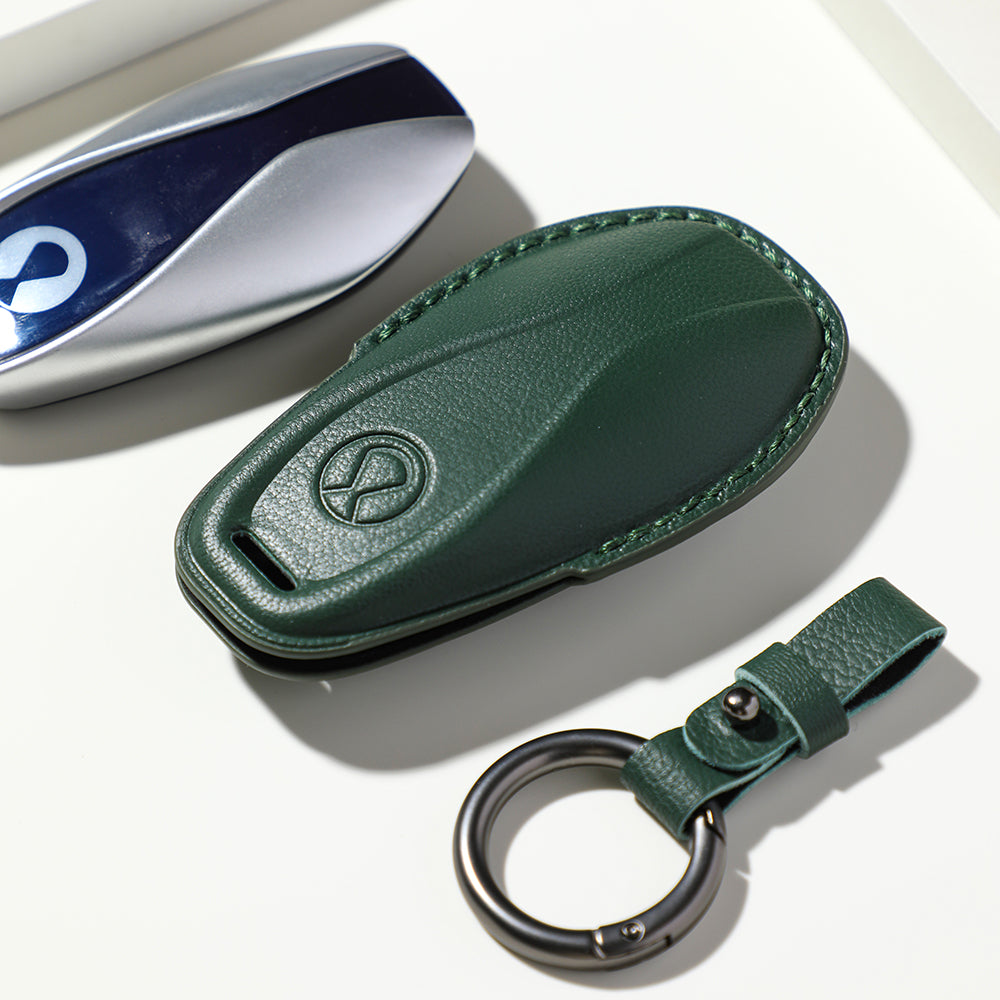 Premium dark green textured leather car key fob cover with matching keychain ring.