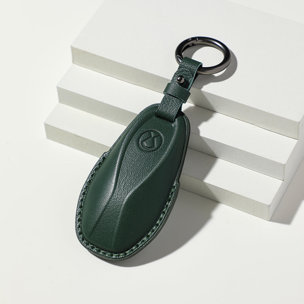 Premium dark green leather car key fob cover with elegant textured finish and metal ring.