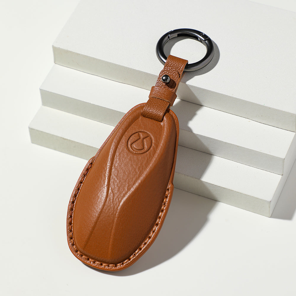 Premium tan leather car key fob cover with embossed logo and durable stitching.