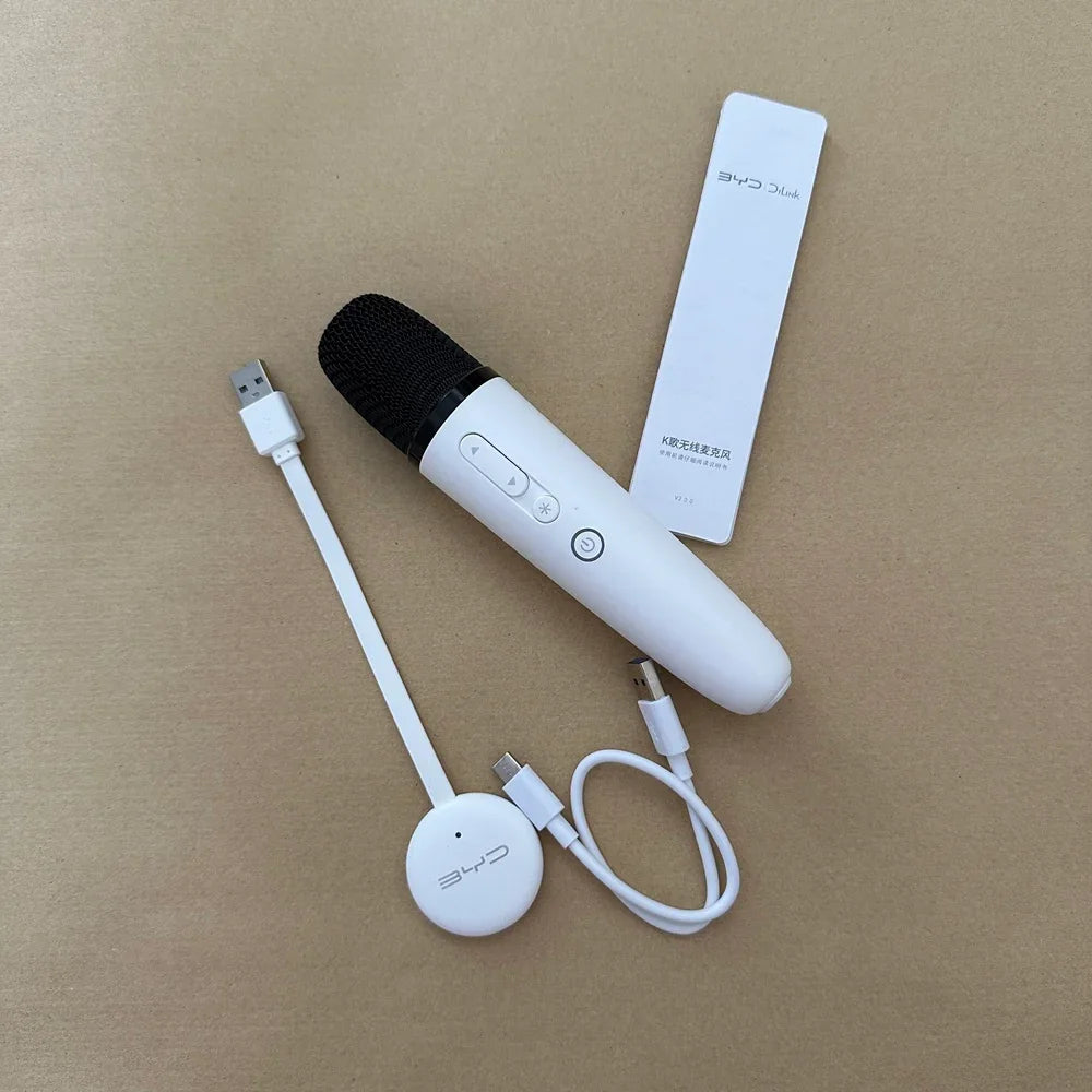White wireless handheld microphone with a compact charging receiver and USB cable.