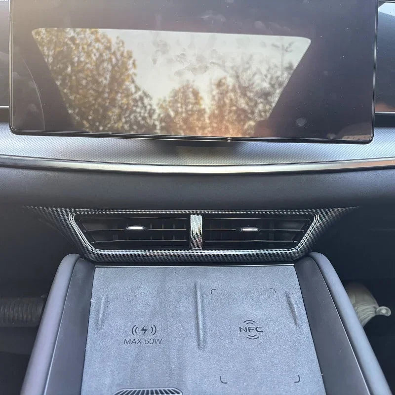 Grey interior console with carbon fiber trim and wireless charging pad for BYD vehicle.