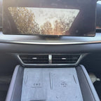 Grey interior console with carbon fiber trim and wireless charging pad for BYD vehicle.