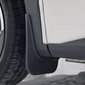 Close-up of a durable matte black plastic mud guard installed on a white vehicle.
