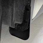 Close-up of a durable black plastic car mud guard installed on a vehicle chassis.
