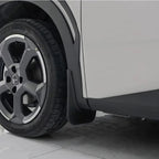 Close-up of a durable matte black plastic mud guard installed behind a car wheel.