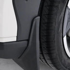 Close-up of a durable matte black plastic mudguard installed behind a car tire.