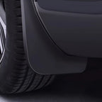 Durable matte black rubber mud flap installed behind the car wheel for splash protection.