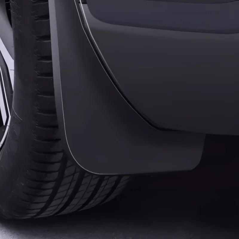 Durable matte black rubber mud flap installed behind the car wheel for splash protection.
