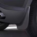 Matte black durable plastic mud flap installed behind the front wheel for vehicle protection.