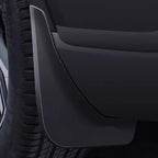 Close-up of a durable matte black plastic mud guard installed behind a car tire.