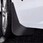 Professional matte black plastic car mud flap installed on a white vehicle wheel arch.
