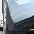 Durable matte black rubber mud flap installed on a light blue car to protect against road debris.