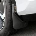 Close-up of a durable matte black plastic mud guard installed behind a car wheel.