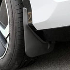 Close-up of a durable matte black plastic mud guard installed behind a car wheel.