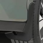 Close-up of a durable matte black plastic car mudguard protecting the wheel arch.