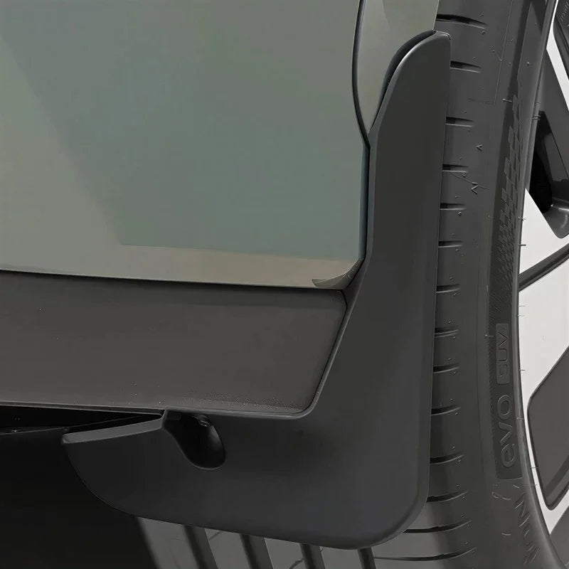 Close-up of a durable matte black plastic car mudguard protecting the wheel arch.