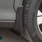 Close-up of a matte black durable plastic mud guard installed behind a car tire.