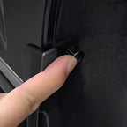 Close-up of a black plastic car accessory being secured with a screw for a precise fit.