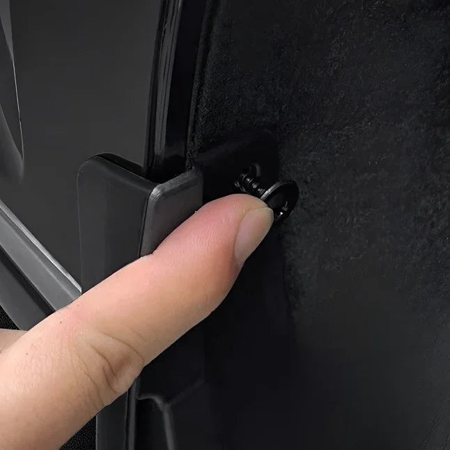 Close-up of a black plastic car accessory being secured with a screw for a precise fit.
