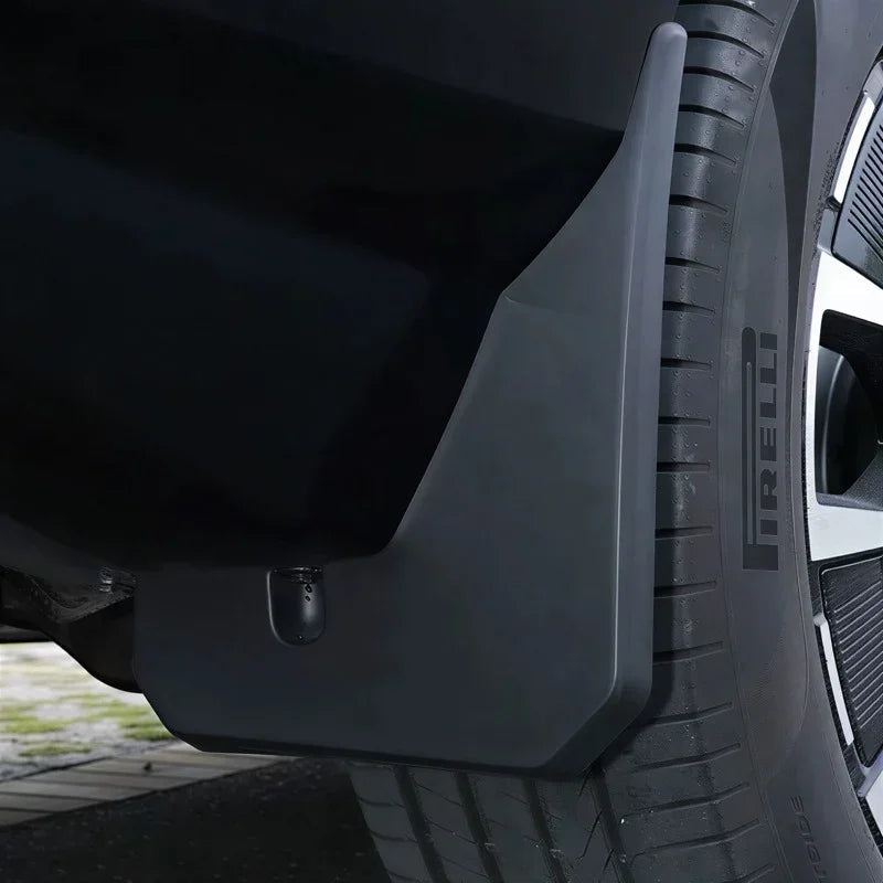 Durable matte black heavy-duty mud flap installed behind the vehicle tire for splash protection.
