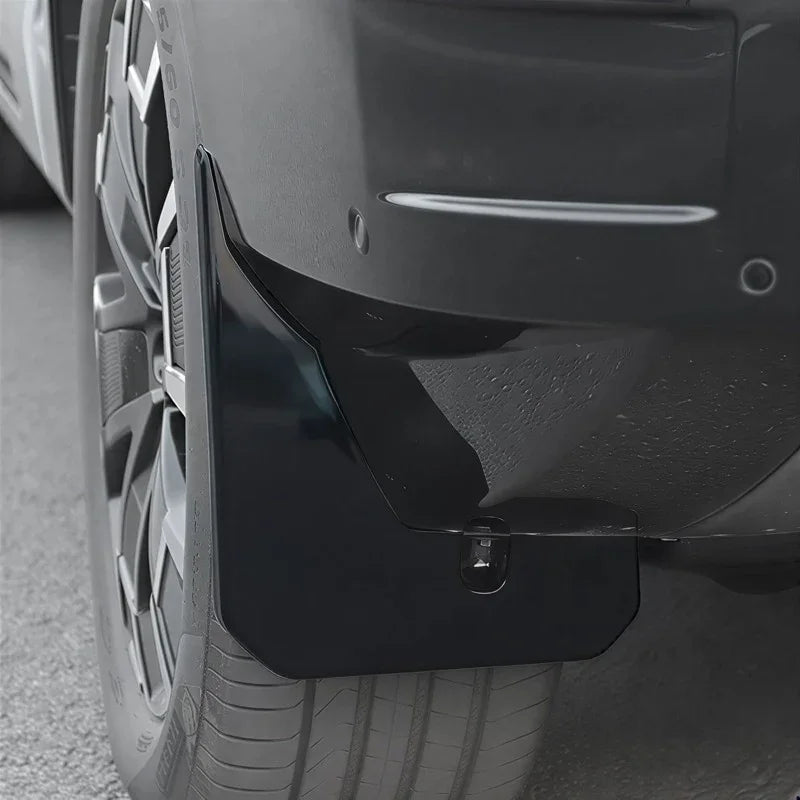 Sleek black glossy mud flap installed on a car wheel arch for premium protection.