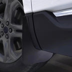 Black matte durable rubber mud flap installed on a white vehicle wheel arch for protection.