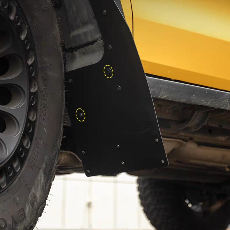 Durable black matte mud flap installed on a yellow vehicle for off-road protection.