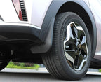 Black matte durable rubber mud flap installed behind the tire of a white SUV.