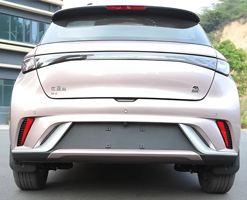 Rear view of a light pink BYD EV with sleek LED taillights and a modern bumper design.