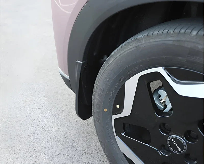 Black durable rubber mud flap installed behind the wheel of a pink BYD vehicle.