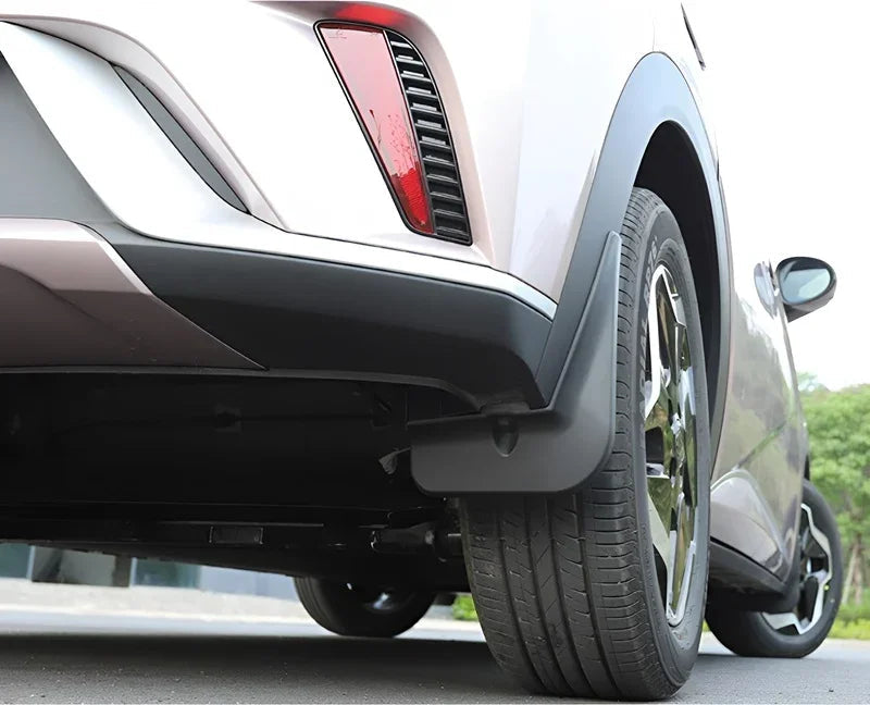 Black durable plastic mud flap installed on a light pink BYD vehicle rear wheel arch.