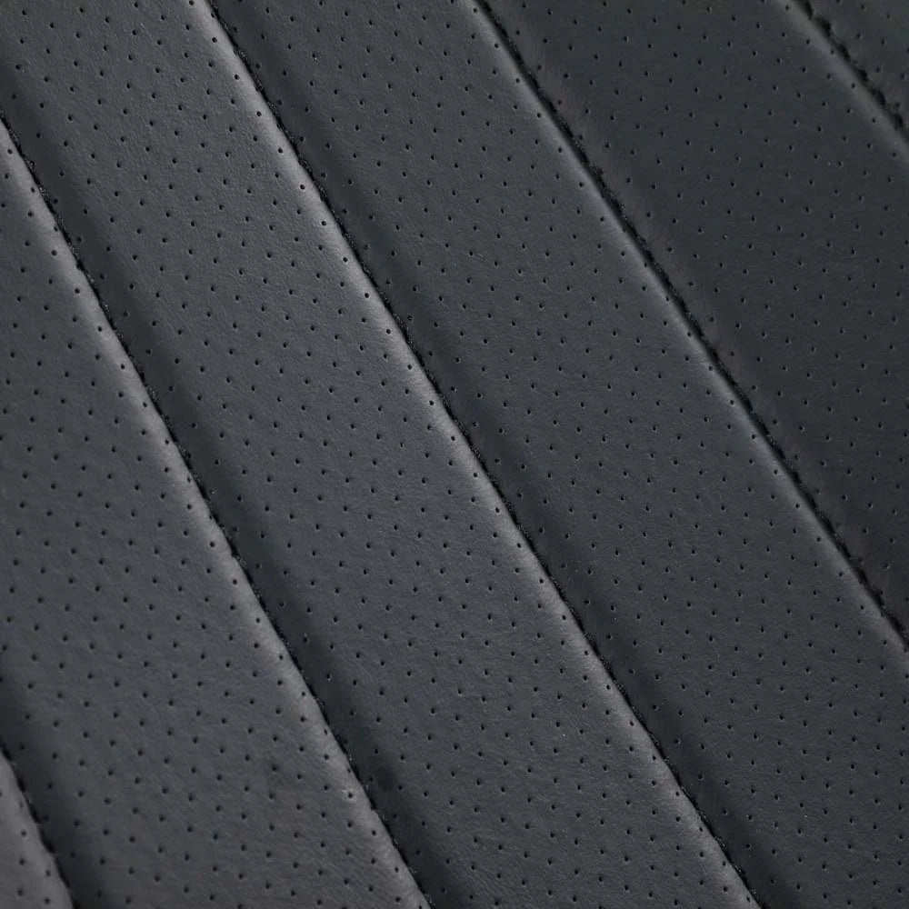 Close-up of premium perforated black leather car seat upholstery with diagonal stitching.