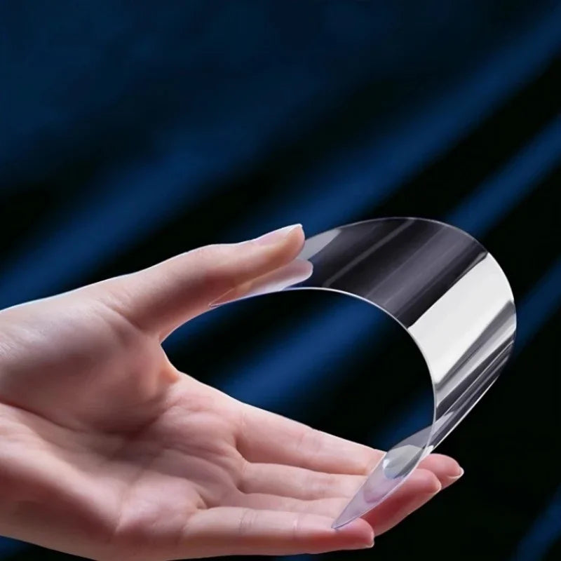 Hand holding a flexible, transparent clear protective film for car interiors.