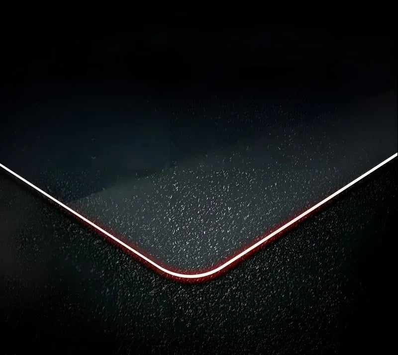 Close-up of textured black protective surface with a sleek red illuminated edge.
