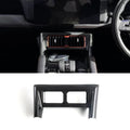 Black carbon fiber trim panel for car center console air vent surround.