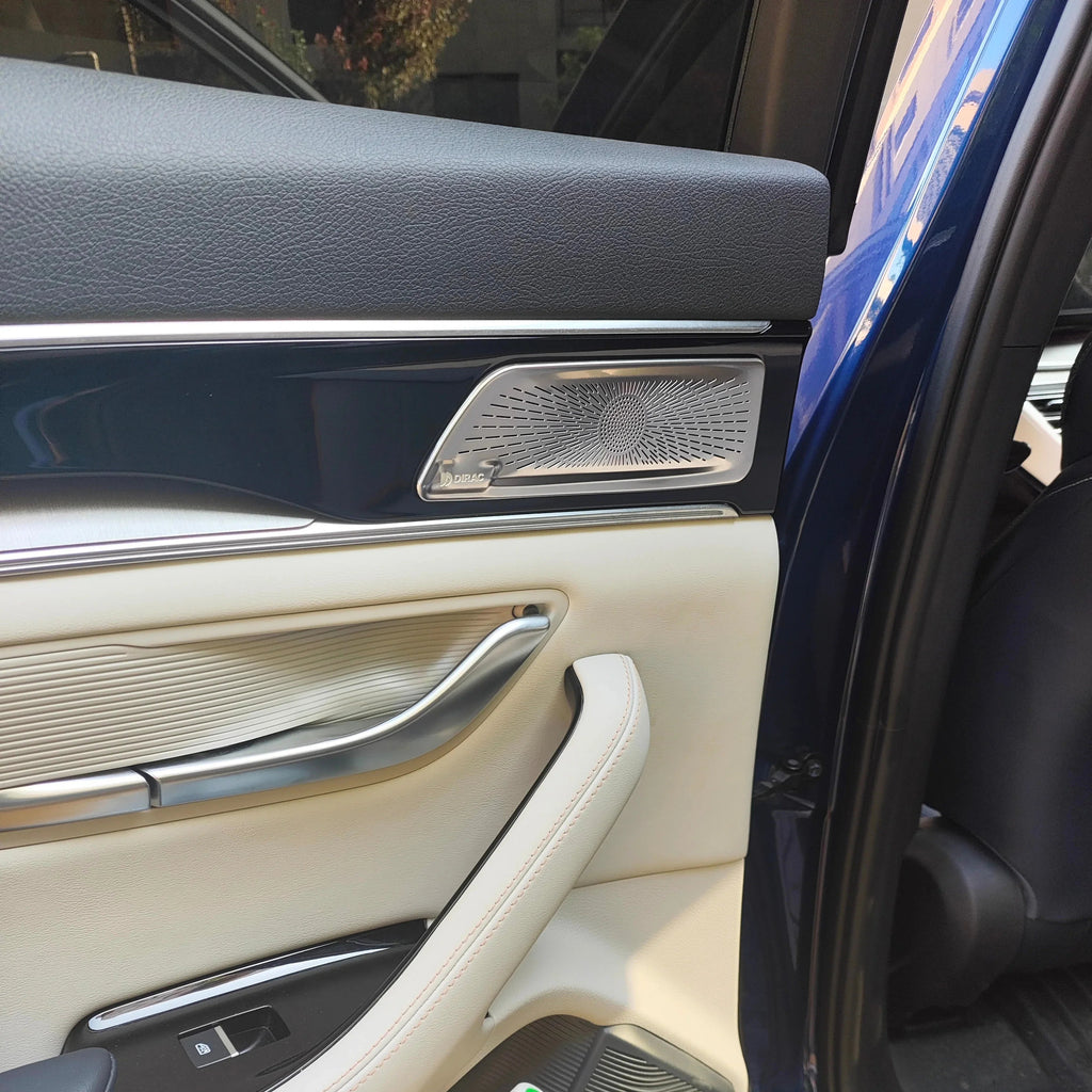 Premium cream leather car door panel with black trim and silver metallic speaker grille.