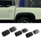 Set of six matte black textured door scuff plates for car protection.